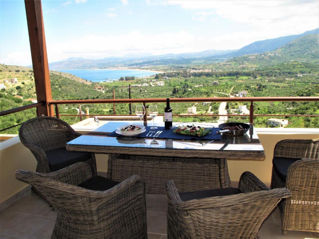 a table and chairs on a balcony with a view at Wormwood - Morfi Village in Georgioupolis