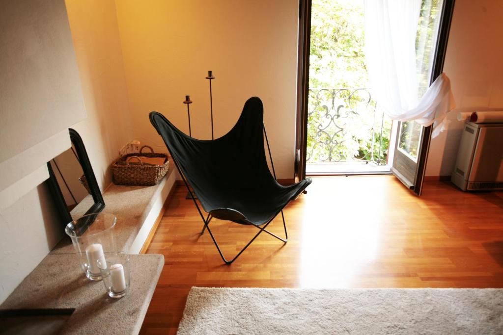 een zwarte hangmat in een woonkamer met een raam bij Cozy apartment in the green in Locarno
