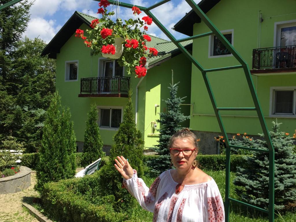 プレデアルにあるVila Bogdanaの緑の建物の前に立つ女