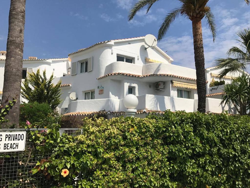 a white house with palm trees in front of it at Camino del Vasco in Denia