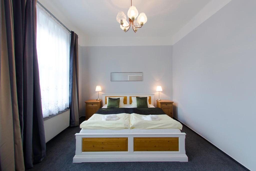 a bedroom with a white bed and a window at Hotel Soudek in Poděbrady