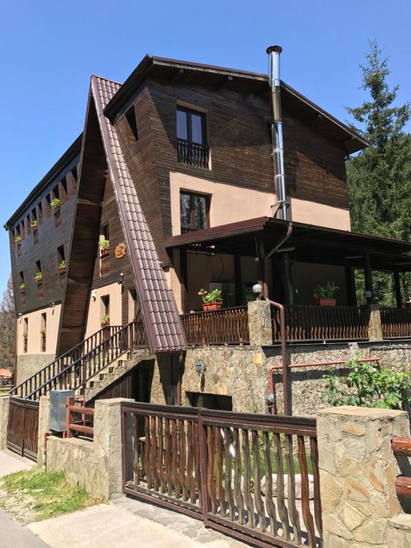 ein großes Holzhaus mit Balkon in der Unterkunft Pensiunea Mario in Moieciu de Sus