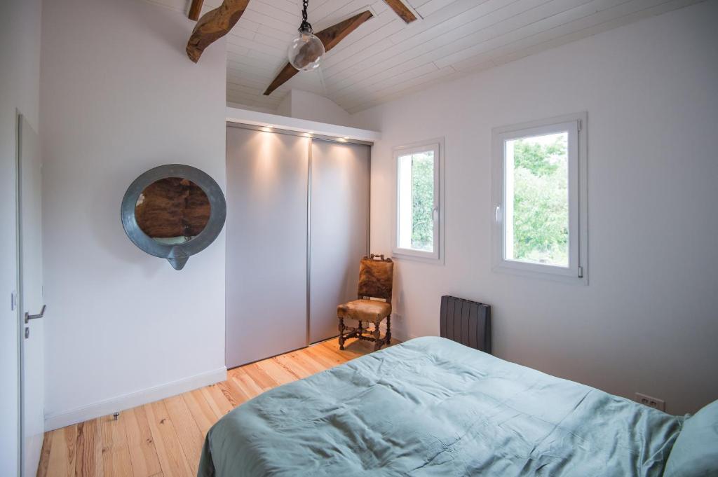 アムーにあるLuxury Little Cottageのベッドルーム1室(ベッド1台、椅子1脚、窓2つ付)