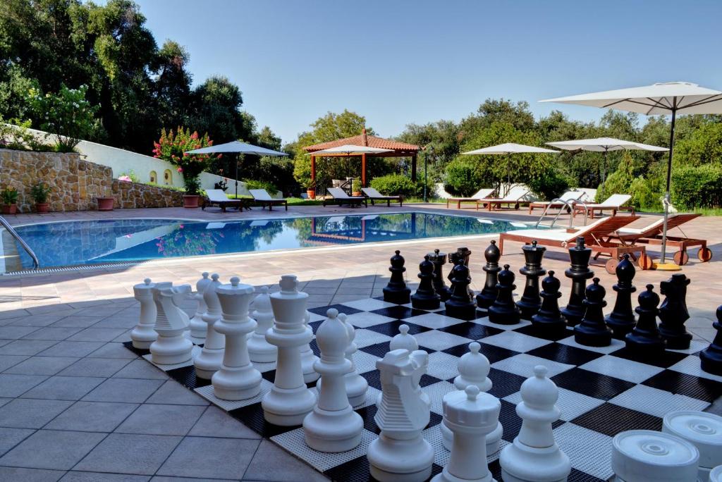 a chess board is sitting next to a pool at Archontiko Loukis in Pentati
