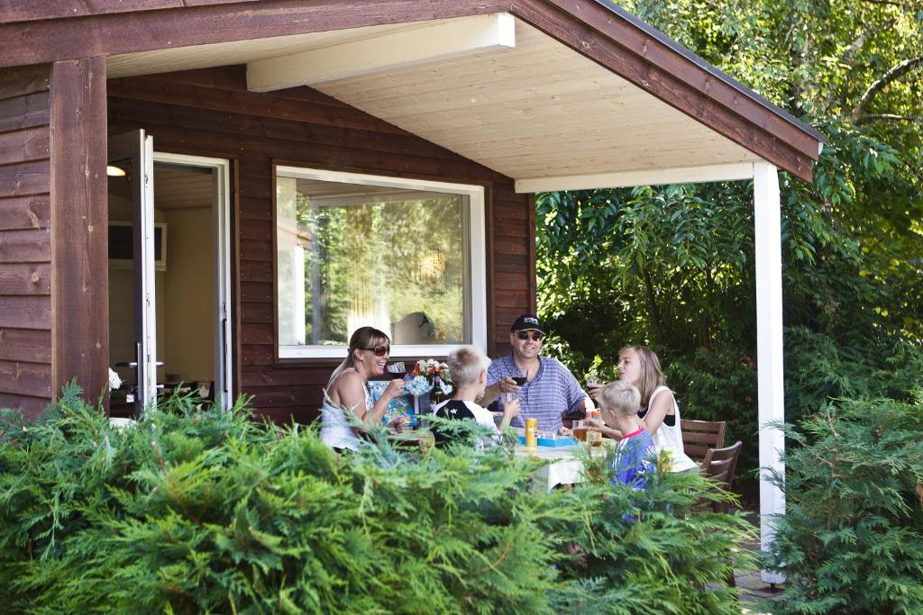 een groep mensen die rond een tafel op een veranda zitten bij CampWest in Oksbøl