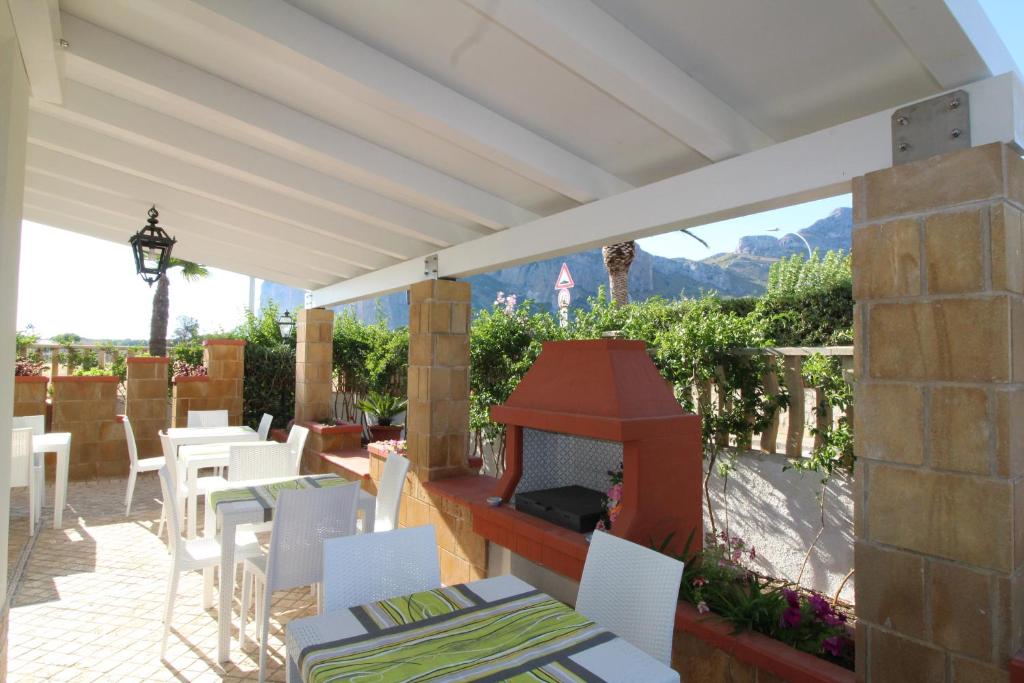 a patio with a fireplace and tables and chairs at B&B Villa Bea in San Vito lo Capo