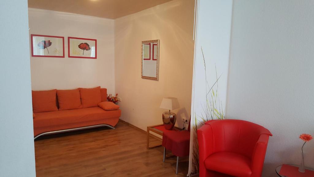 salon z kanapą i czerwonym krzesłem w obiekcie Haus Christiane w mieście Cochem