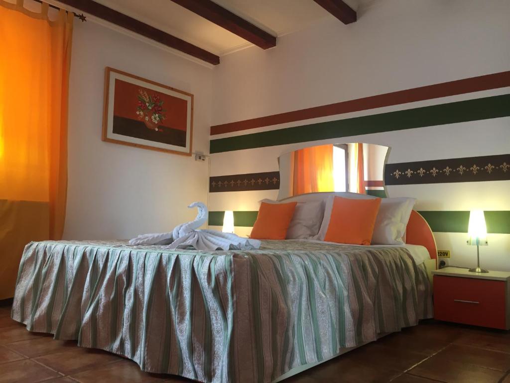 ラシュノフにあるPensiunea Belvedereのベッドルーム1室(オレンジと緑のストライプを用いた大型ベッド1台付)
