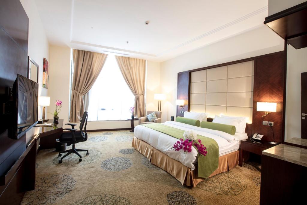 una camera d'albergo con un grande letto e una TV di Prime Al Hamra Hotel a Gedda