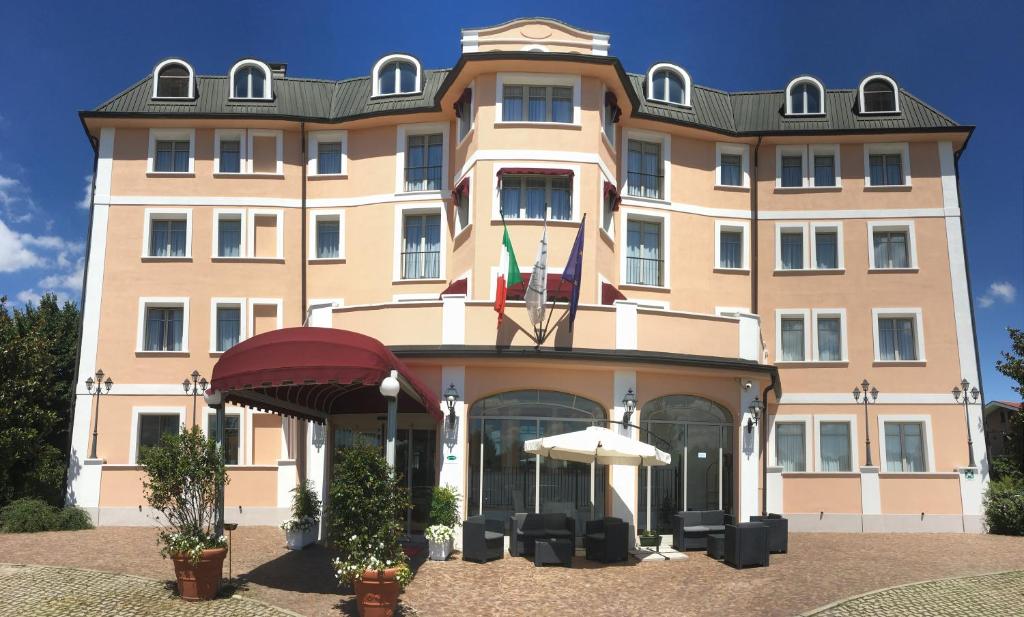 a large building with two flags on top of it at Green Hotel in Settimo Torinese