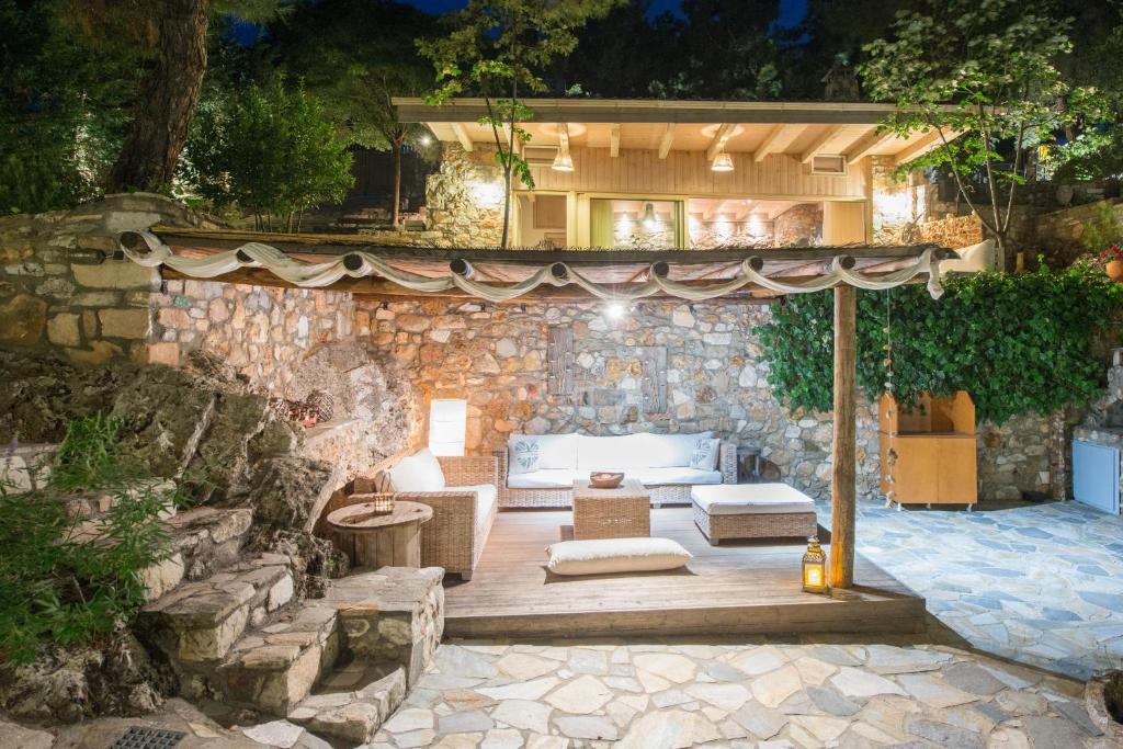 Casa de piedra con patio y sofá en Amicasa Private Seaside Suite, en Pachis