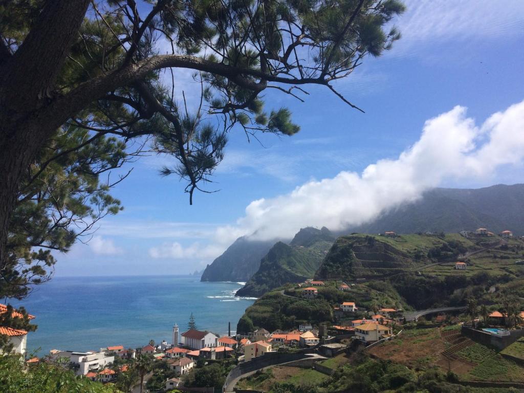 Blick auf das Meer und eine Stadt auf einem Hügel in der Unterkunft Pereira's house - Mountain & Sea in Porto da Cruz