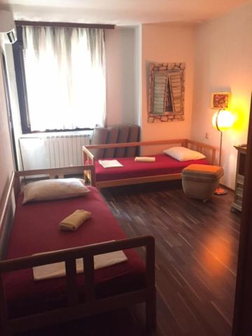 uma sala de estar com duas camas e uma janela em Rooms Ana em Kotor