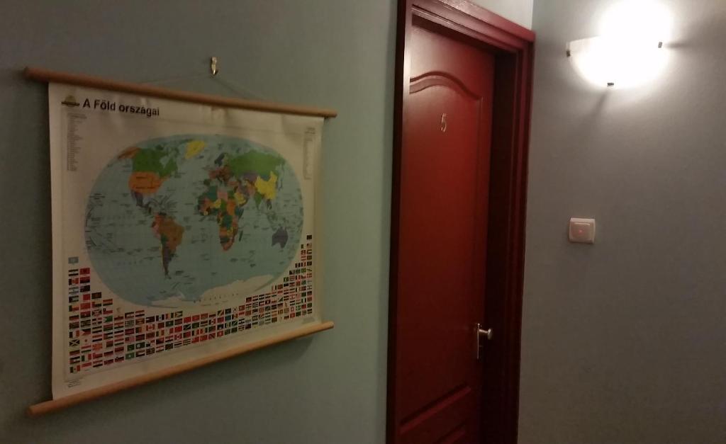 a map of the world hanging on a wall next to a door at Palma Panzio in Fót