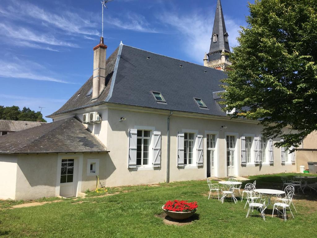 - un bâtiment blanc avec une table et des chaises dans la cour dans l'établissement Le Presbytère, à Menetou-Salon