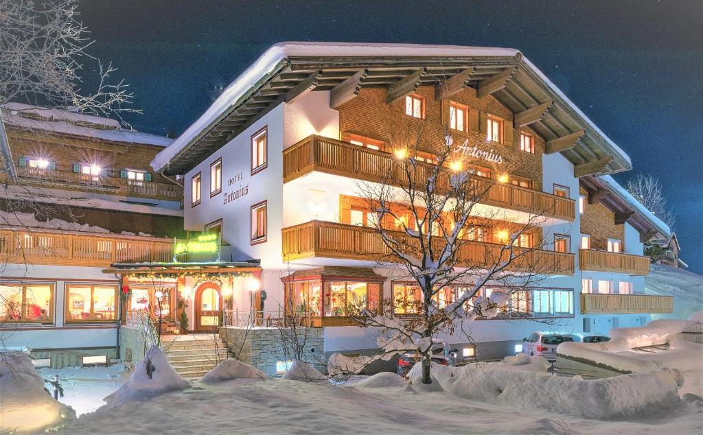 レッヒにあるAntonius Hotel Garni in Lechの夜雪の大きな建物