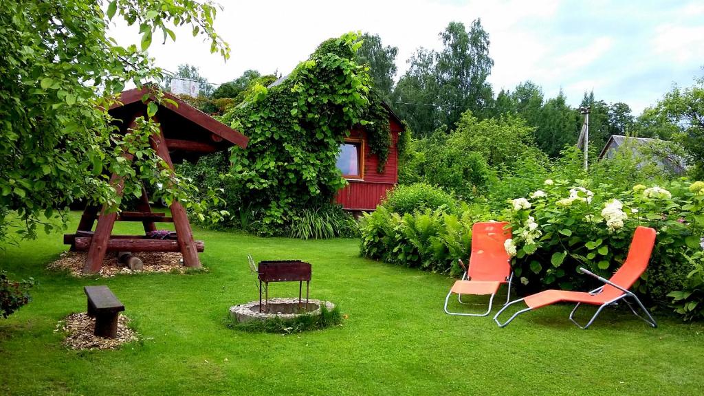 a yard with chairs and a table and a house at Pie Anninas in Krāslava