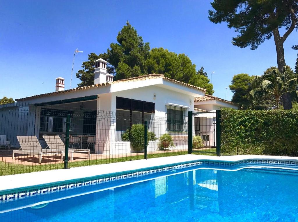 ein Haus mit Pool davor in der Unterkunft La Huerta Pintada in El Puerto de Santa María