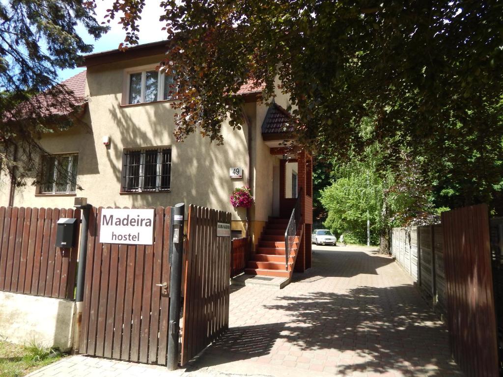 une maison dotée d'une clôture en bois et d'un panneau. dans l'établissement Hostel Madeira, à Gdańsk