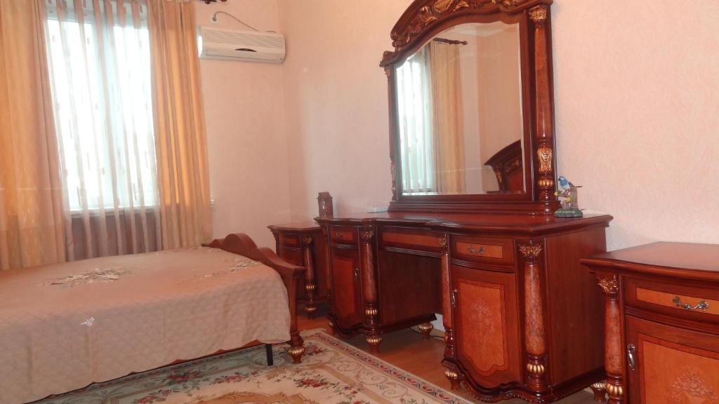 a bedroom with a dresser and a mirror and a bed at Apartment vake-saburtalo in Tbilisi City