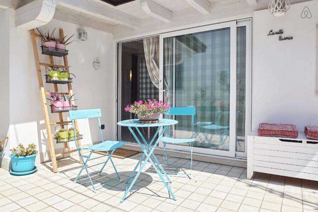 un patio con 2 sillas y una mesa con flores. en Casetta Bianca B&B, en San Giovanni Lupatoto