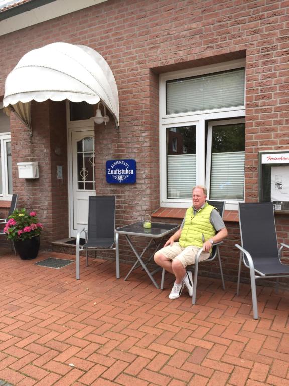 ノルダーナイにあるFerienhaus Zunftstubenの椅子に座る男