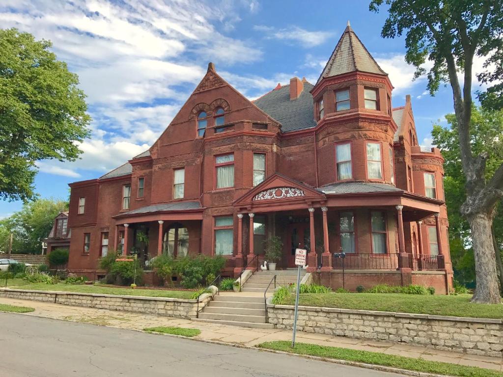duży budynek z czerwonej cegły na rogu ulicy w obiekcie Vineyard Mansion Carriage House w mieście Saint Joseph