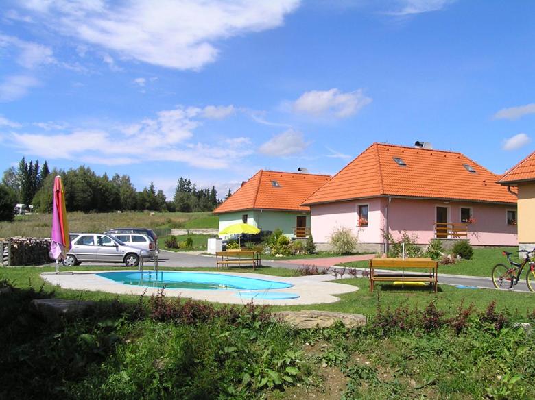 a car parked next to a house with a swimming pool at Apartmány holiday Frymburk in Frymburk