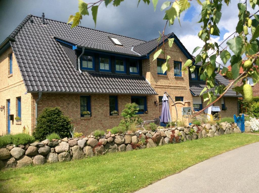 a house with a stone fence in front of it at Ferienwohnung "Alter Gutshof" Hühnergott in Ostseebad Sellin