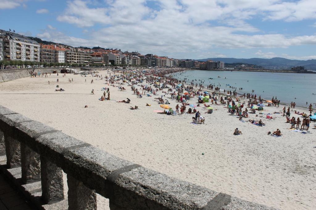 un gran grupo de personas en una playa en Piso en primera línea Sanxenxo, en Sanxenxo