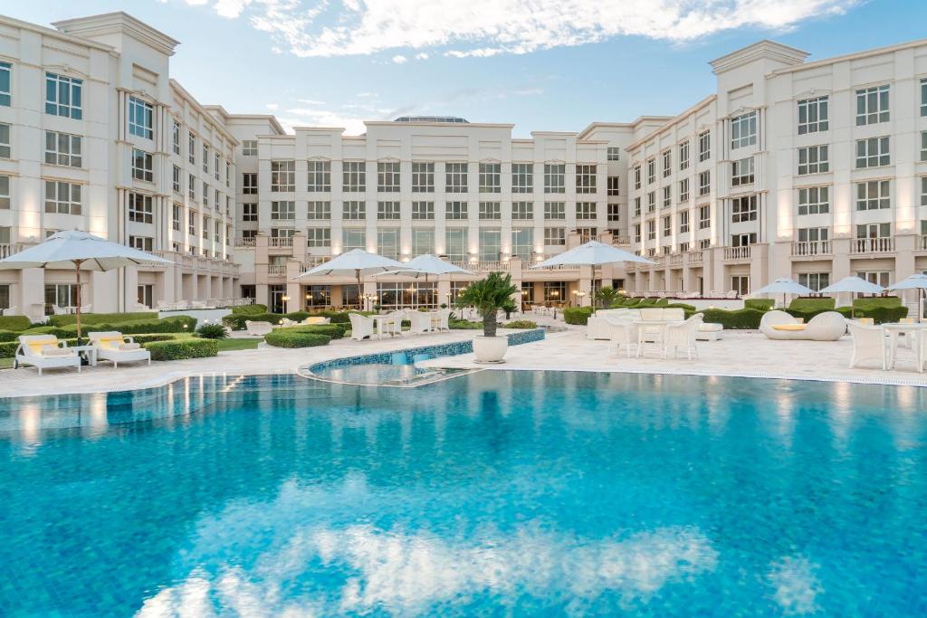 an exterior view of a hotel with a large pool at The Regency Hotel Kuwait in Kuwait