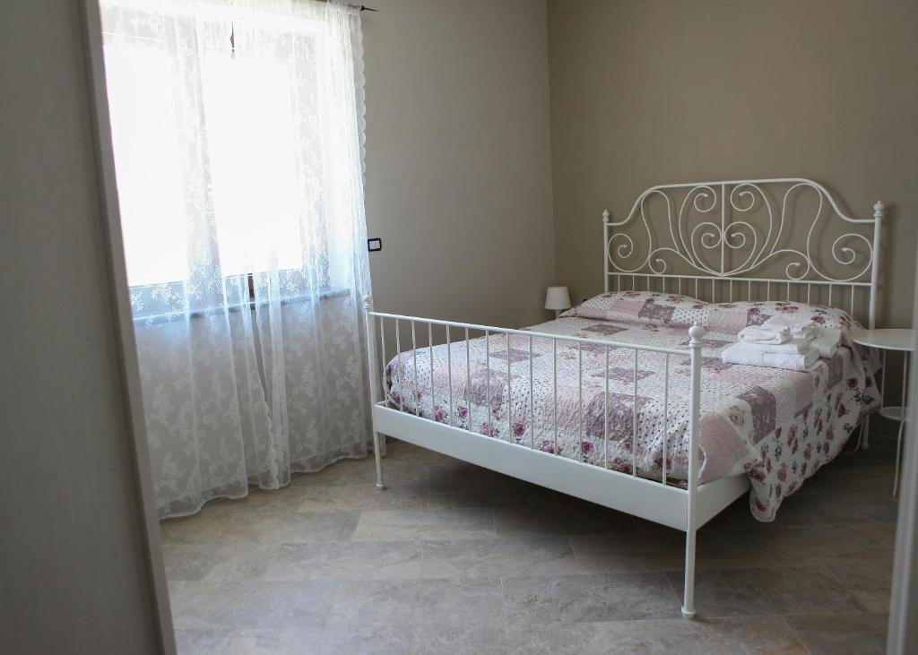 a bedroom with a white bed and a window at B&B Masseria Cozzi in Lauria Inferiore