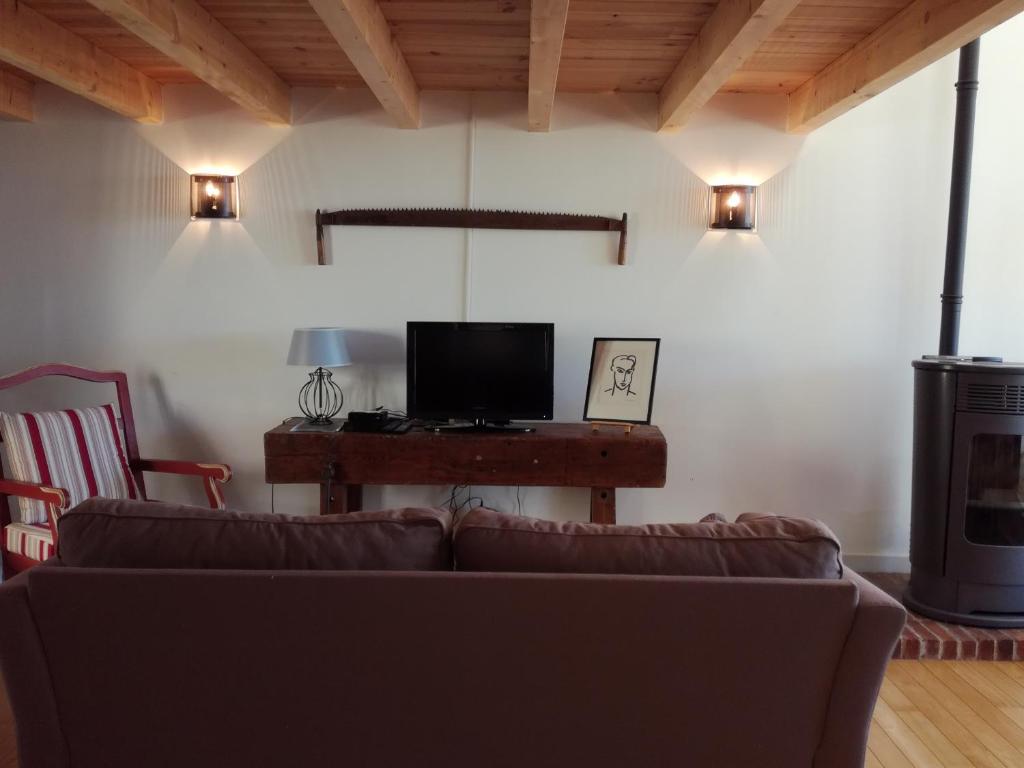 a living room with a couch and a television at Gîte du Besset in Pradelles