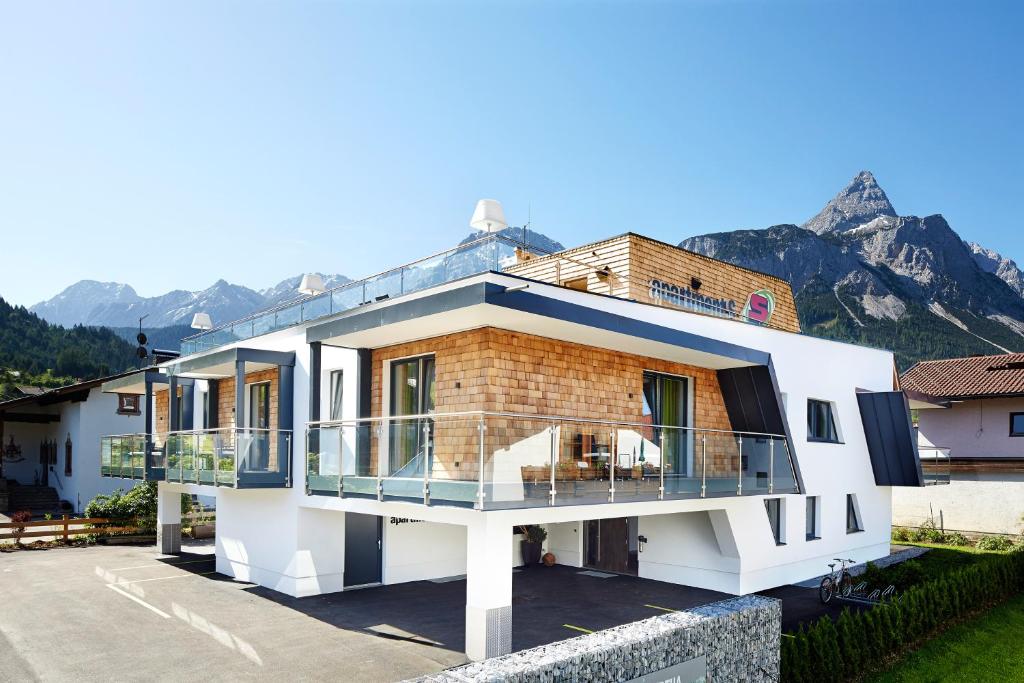 ein Haus mit einem Balkon mit Bergblick im Hintergrund in der Unterkunft Apartment S in Ehrwald