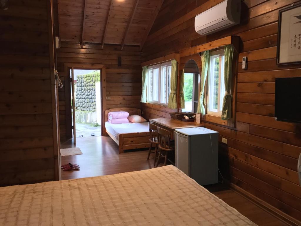 - une chambre avec un lit et un bureau dans l'établissement Jin Zu Cottage, à Lugu