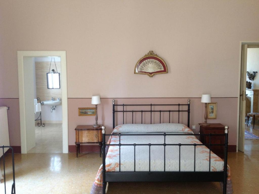 1 dormitorio con cama y espejo en la pared en B&B Lauretum, en Loreto Aprutino