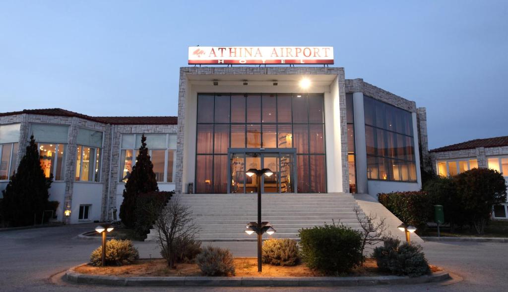 
a large building with a clock on the front of it at Athina Airport Hotel in Thermi
