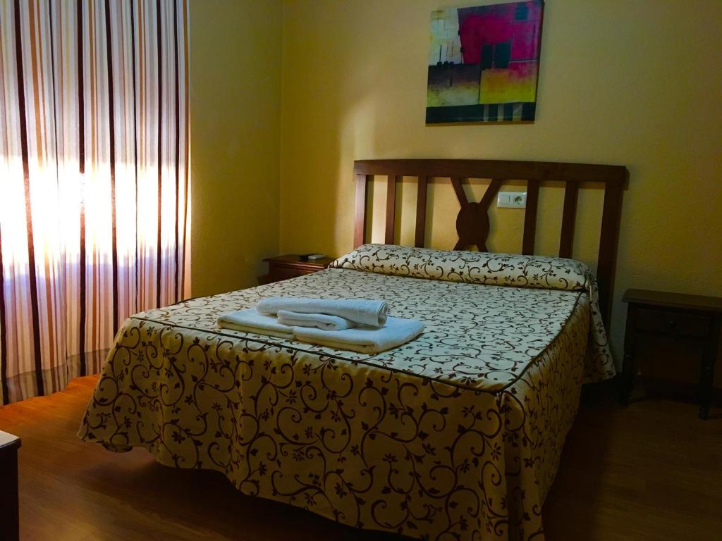 1 dormitorio con 1 cama con 2 toallas en Hosteria Verahouse, en Jaraíz de la Vera