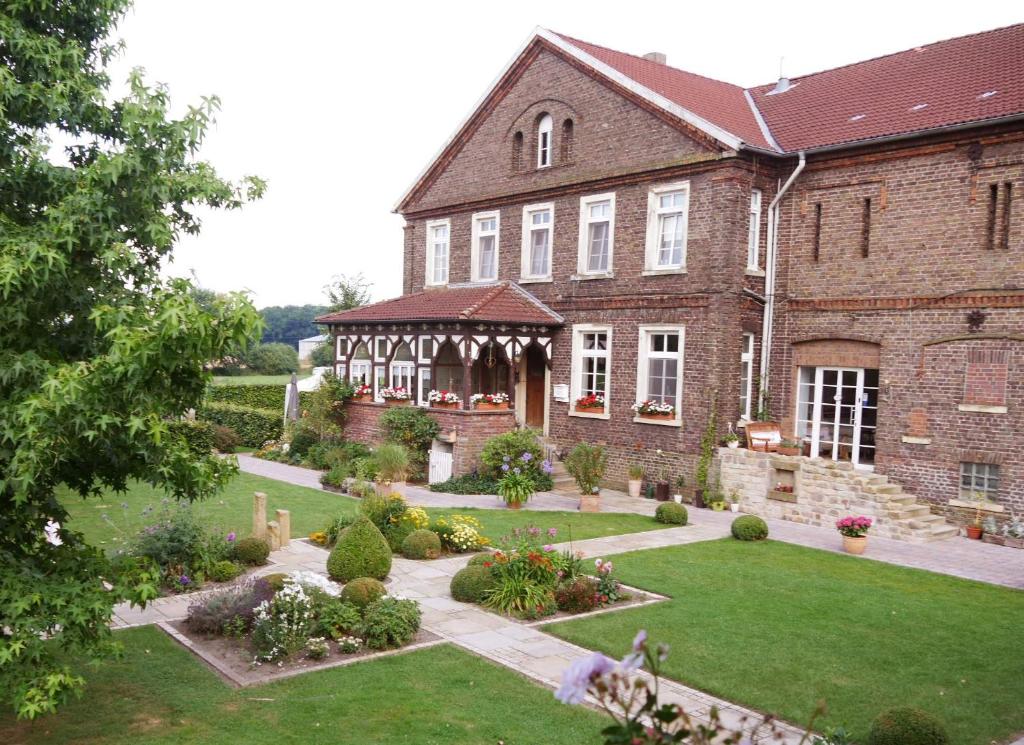 a large brick building with a garden in front of it at Bleckmanns Hof in Werne an der Lippe