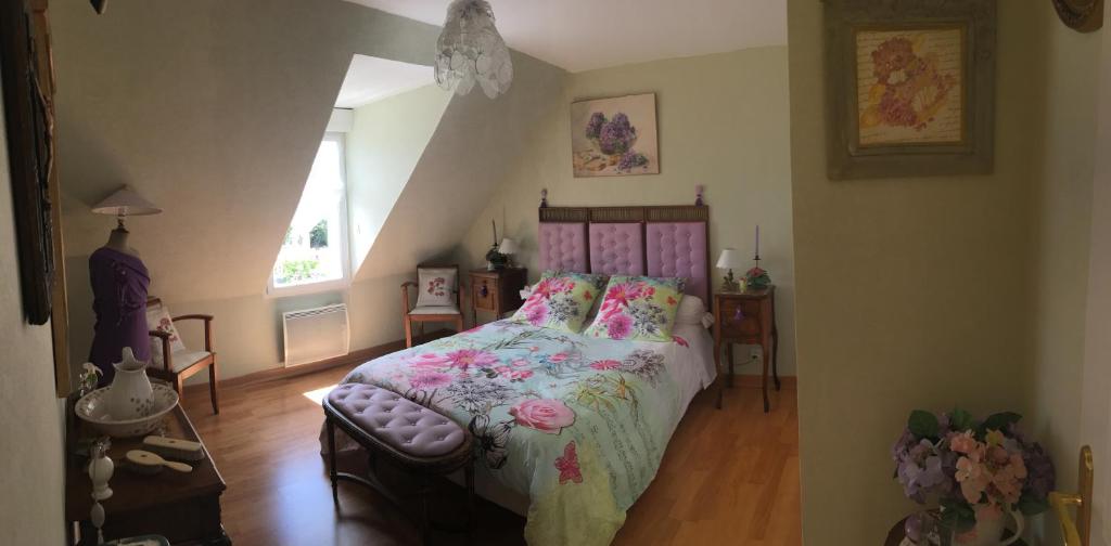 1 Schlafzimmer mit einem Bett mit Blumenbettdecke in der Unterkunft Villa Magdanic in Moëlan-sur-Mer