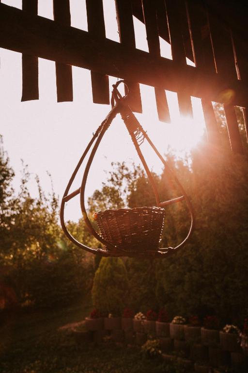 a basket hanging from a fence with the sun in the background at Bosnyák Panzió in Odorheiu Secuiesc