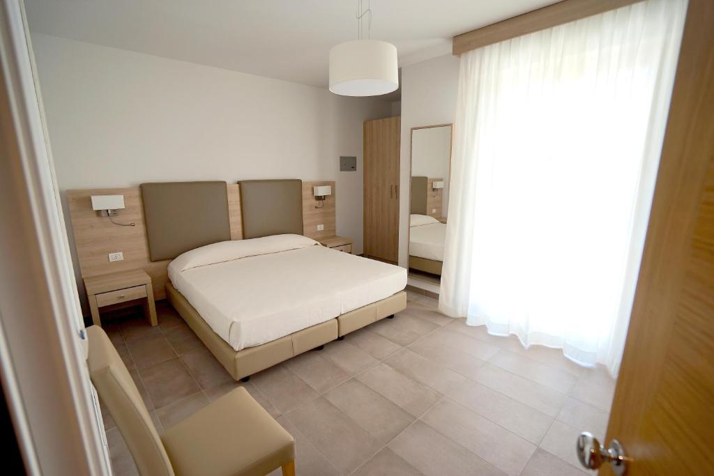 阿爾蓋羅的住宿－Rooms Angedras，卧室配有1张床、1张桌子和1把椅子