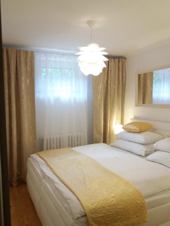 a bedroom with two beds and a chandelier at Apartmán Amália in Banská Bystrica