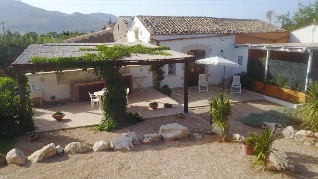 dom z patio ze stołem i krzesłami w obiekcie Lovely Cottage w mieście Castellammare del Golfo