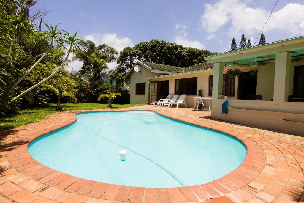 a swimming pool in front of a house at Parkers Cottages in St Lucia