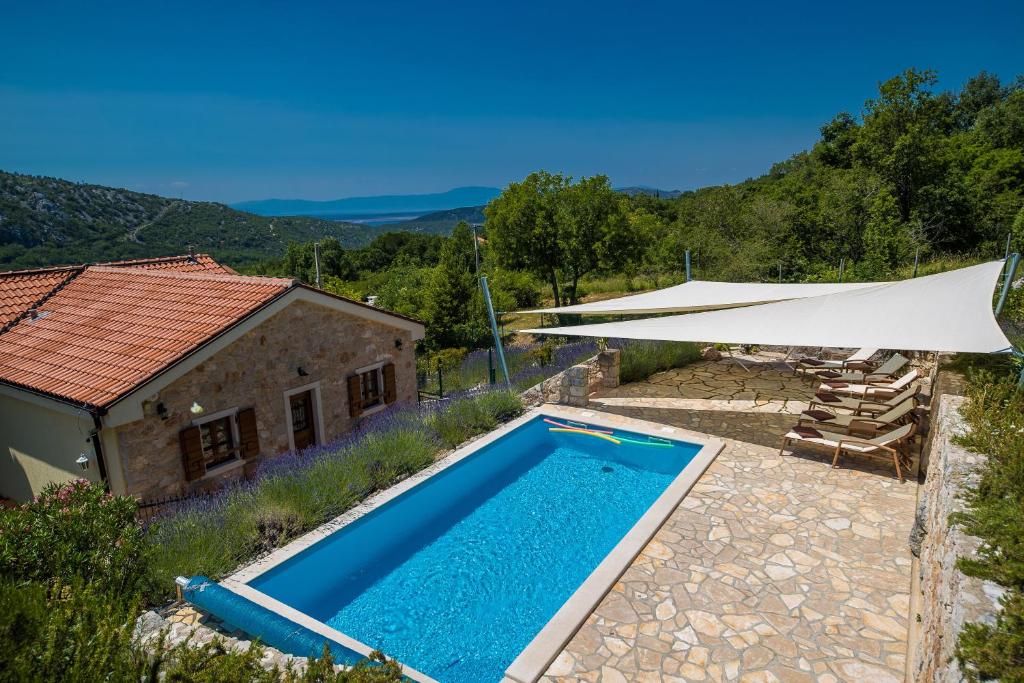 a villa with a swimming pool and a white umbrella at Villa Vallis in Bribir