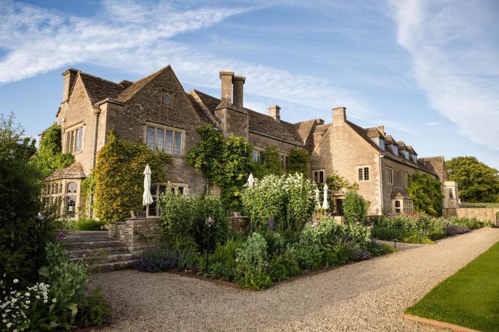 an old house with a garden in front of it at Whatley Manor in Malmesbury