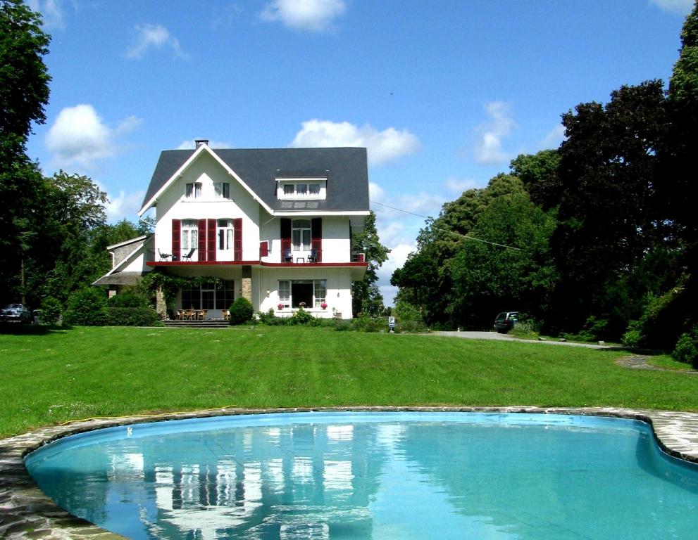 a house with a swimming pool in front of a house at Hotel La Heid des Pairs in Spa