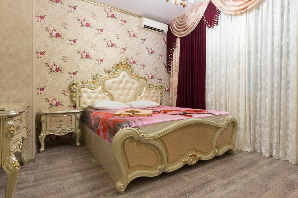 アストラハンにあるApartments Lux pl.Lenina 8のベッドルーム1室(ピンクとゴールドの天蓋付きベッド1台付)