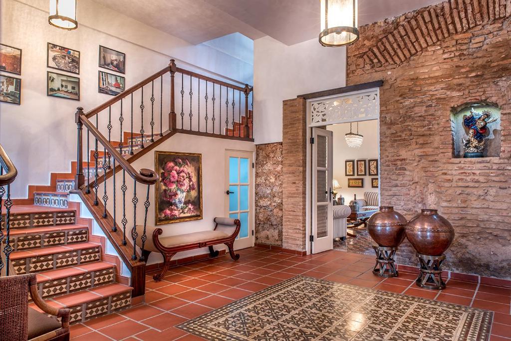 a living room with a staircase and a brick wall at Colonial 154 H Boutique in Santo Domingo